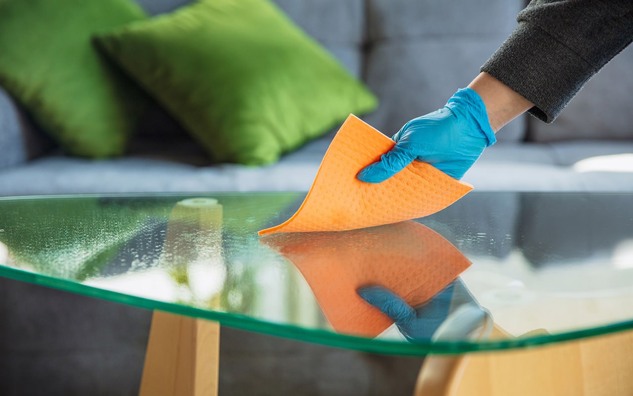 Professional cleaning a galls tabletop with products from Sussex Janitorial Services.